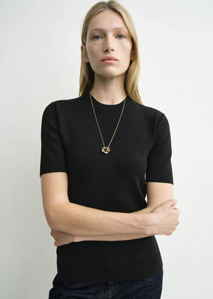 Model wearing the Compact Knit Top in Black by TOTEME, perfect for casual or stylish outfits.