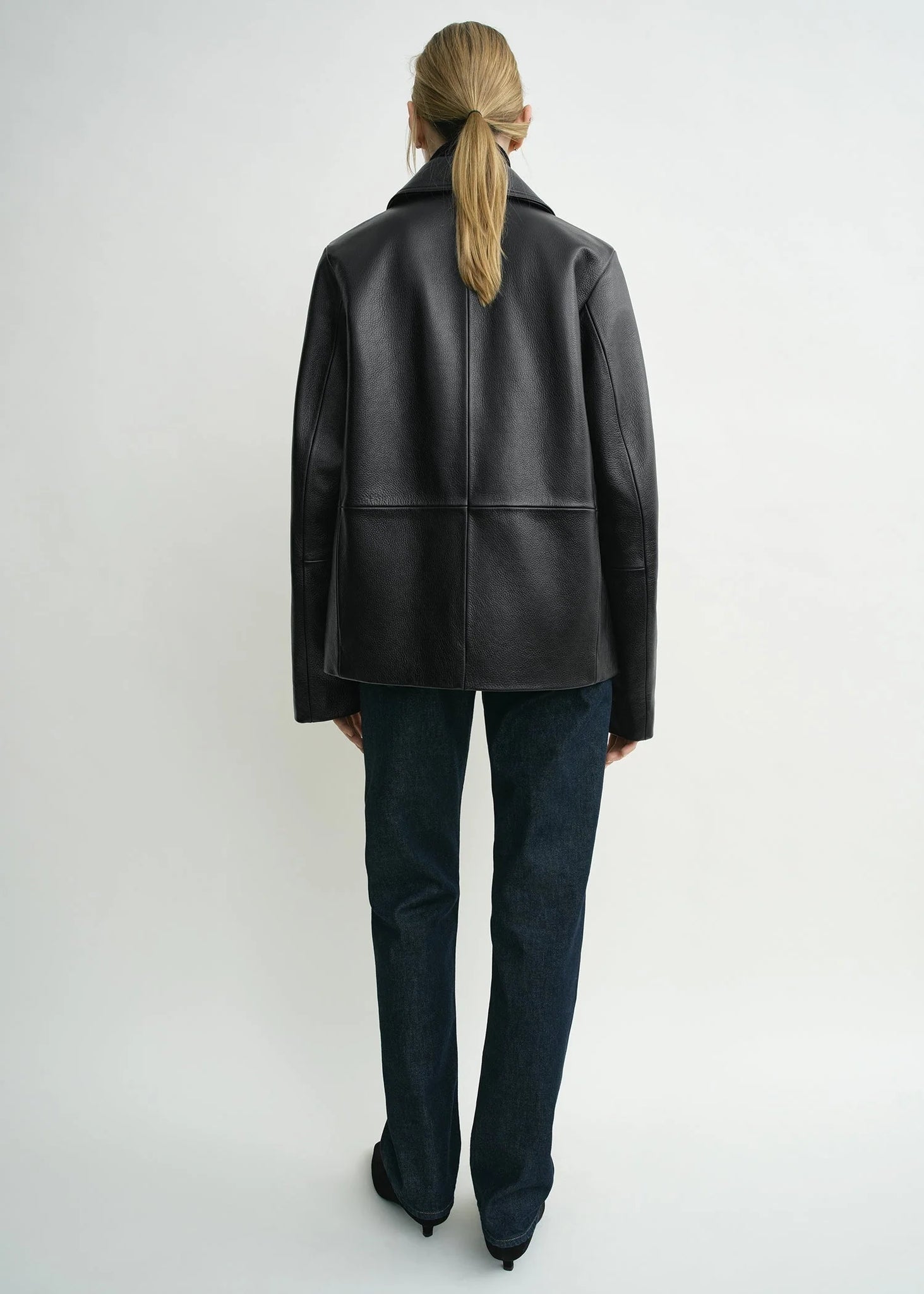 Back view of the Black Grained Leather Jacket from TOTEME, displaying the sleek and modern cut.