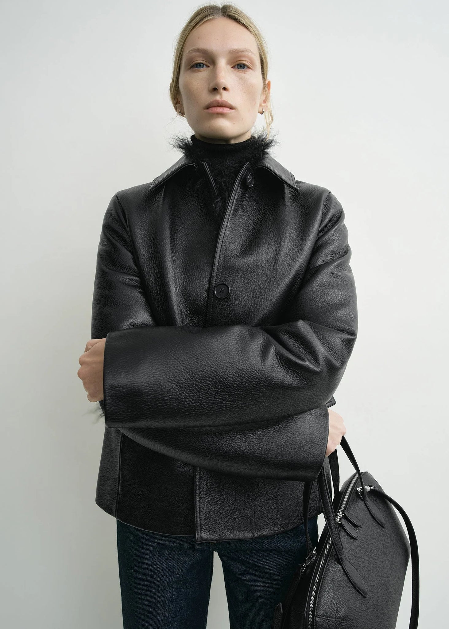 Close-up of the texture of TOTEME's Grained Leather Jacket in Black, showcasing the quality of 100% cow leather.