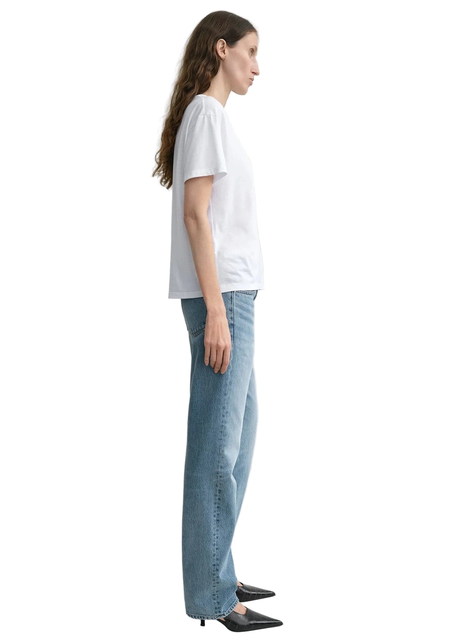 Model wearing Low Straight Jean in True Vintage by TOTEME, styled with heels for a chic look.
