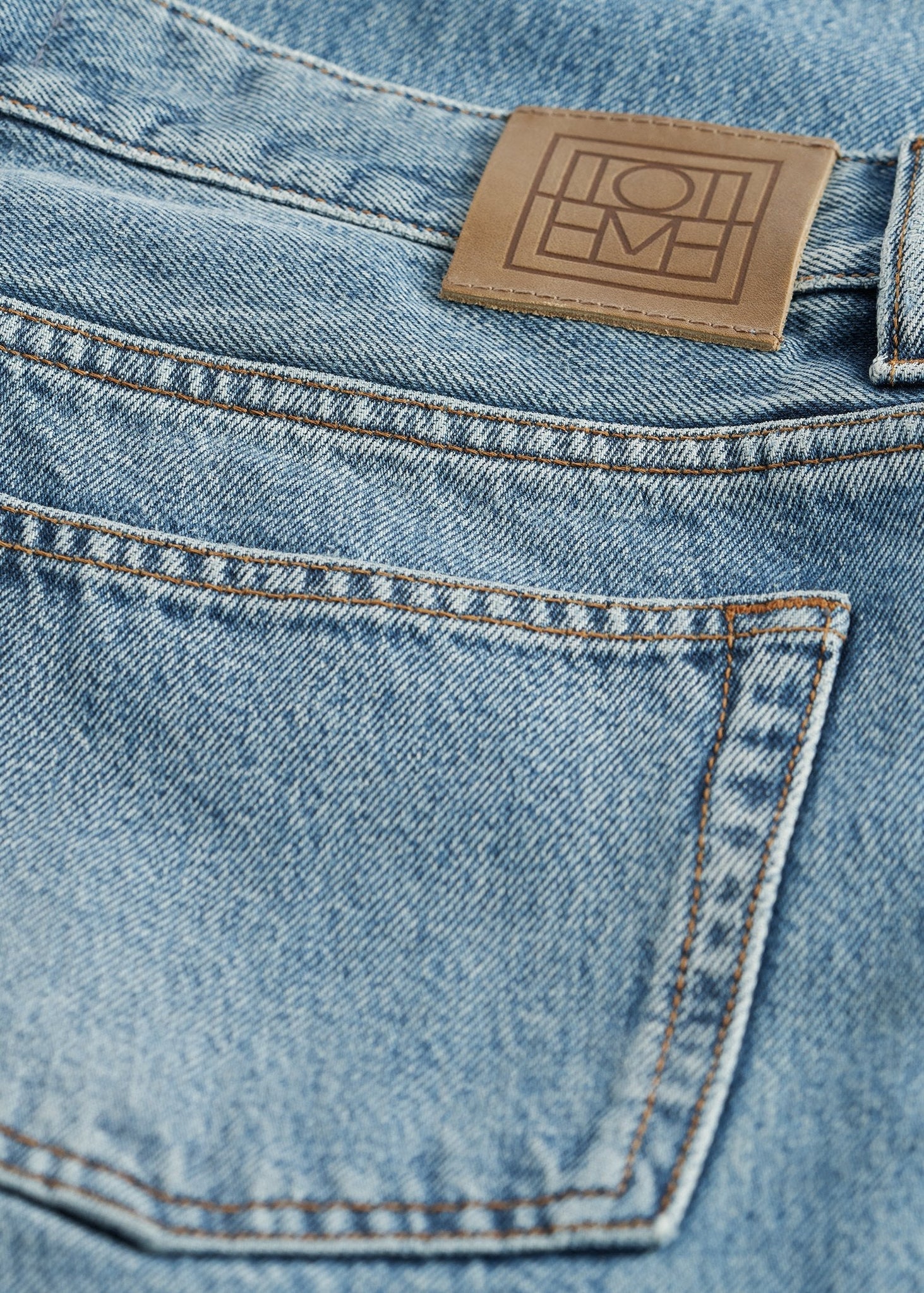 Product detail shot of the Low Straight Jean in True Vintage by TOTEME, focusing on the true vintage wash and organic fabric.