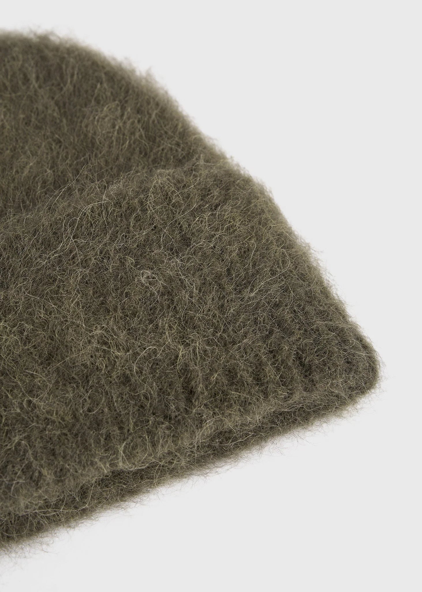 Flat lay of the Alpaca Knit Beanie in Pepper from TOTEME, perfect for winter styling.