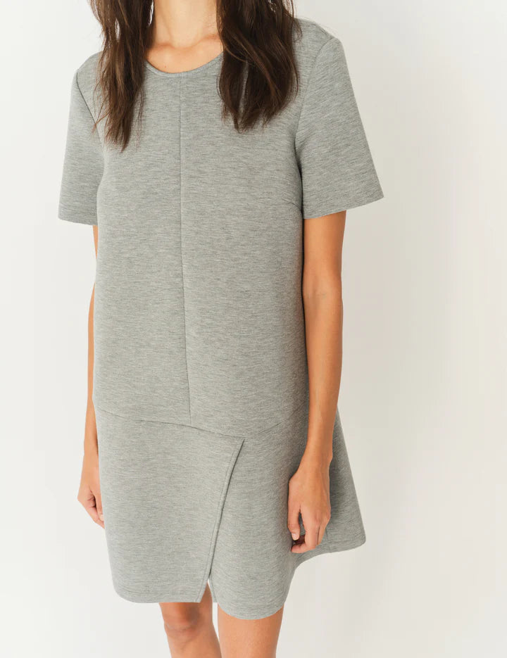 Stylish model wearing the Nice Mini Dress in Grey Melange paired with heels for an elevated look by THE GARMENT.