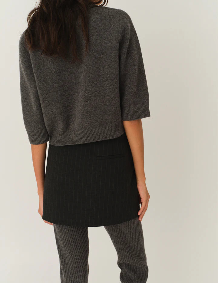 Back view of the Como Short Cardigan in Grey Melange, emphasizing its sophisticated cut and button details.