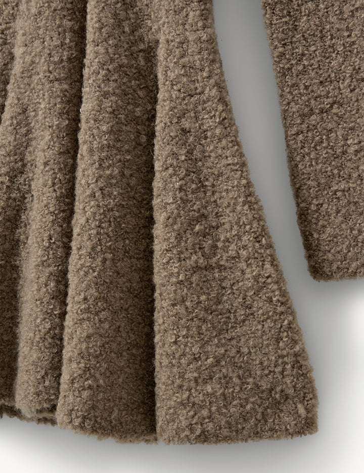 The Balboa Volume Dress in Praline displayed on a hanger, demonstrating its flattering voluminous silhouette.