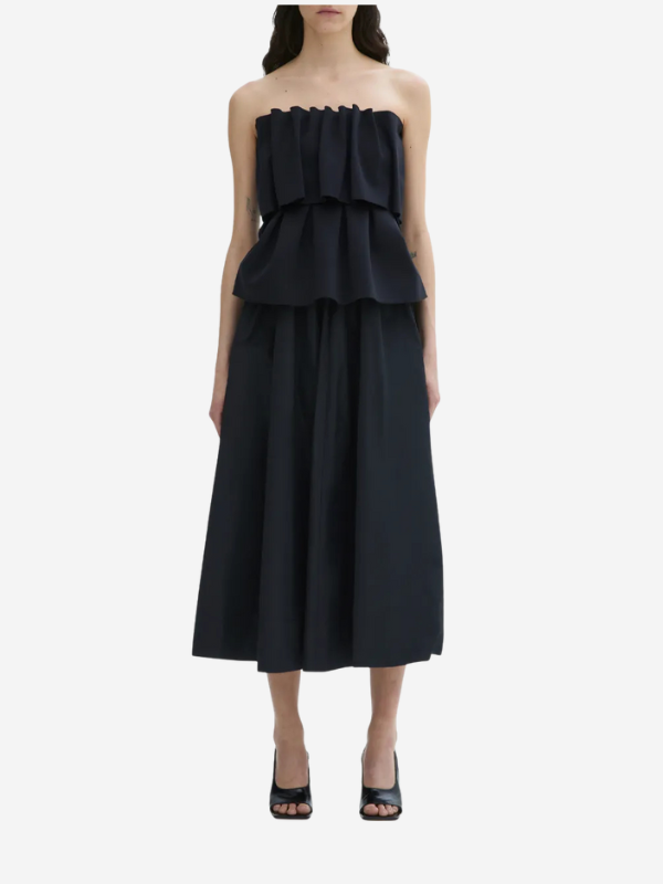 Stylish view of the Sculpted Tube Top in Black by House of Dagmar, showcasing its unique sleeveless design and modern silhouette.