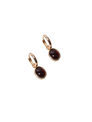 Scarlet Bezel Huggies in Garnet featuring 14kt yellow gold setting with deep garnet cabochon stones.