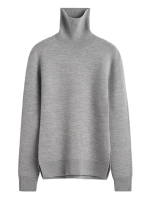 High-neck Double Knit Sweater in Pale Grey Melange showcasing the subtle hourglass silhouette and curved hemline.