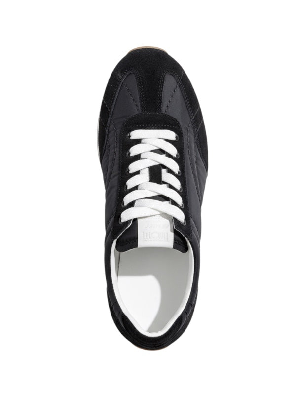 Flat lay of TOTEME Sport Sneakers in Black highlighting the sleek design perfect for weekend off-duty looks.