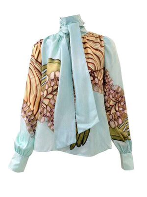 Elegant Ulla Johnson Ornament Tie Neck Blouse in Water Blossom, crafted from lightweight silk chiffon, featuring a stunning floral pattern and a sophisticated high neckline with tie detail.
