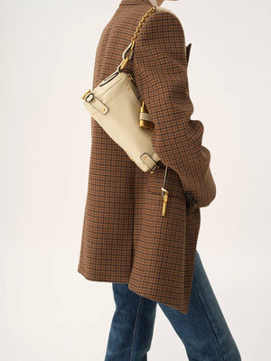 The Small Paddington Chain Bag in Cloudy Cream held by a model highlighting its versatility.
