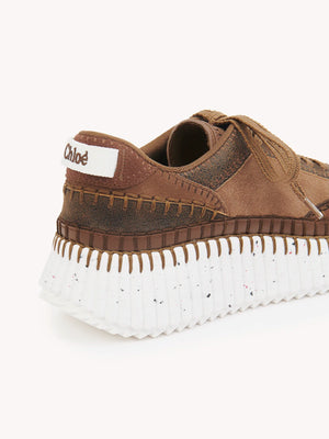 Chloé Nama Sneakers in Oak Brown, elegantly styled to show their trendy design and luxurious materials.